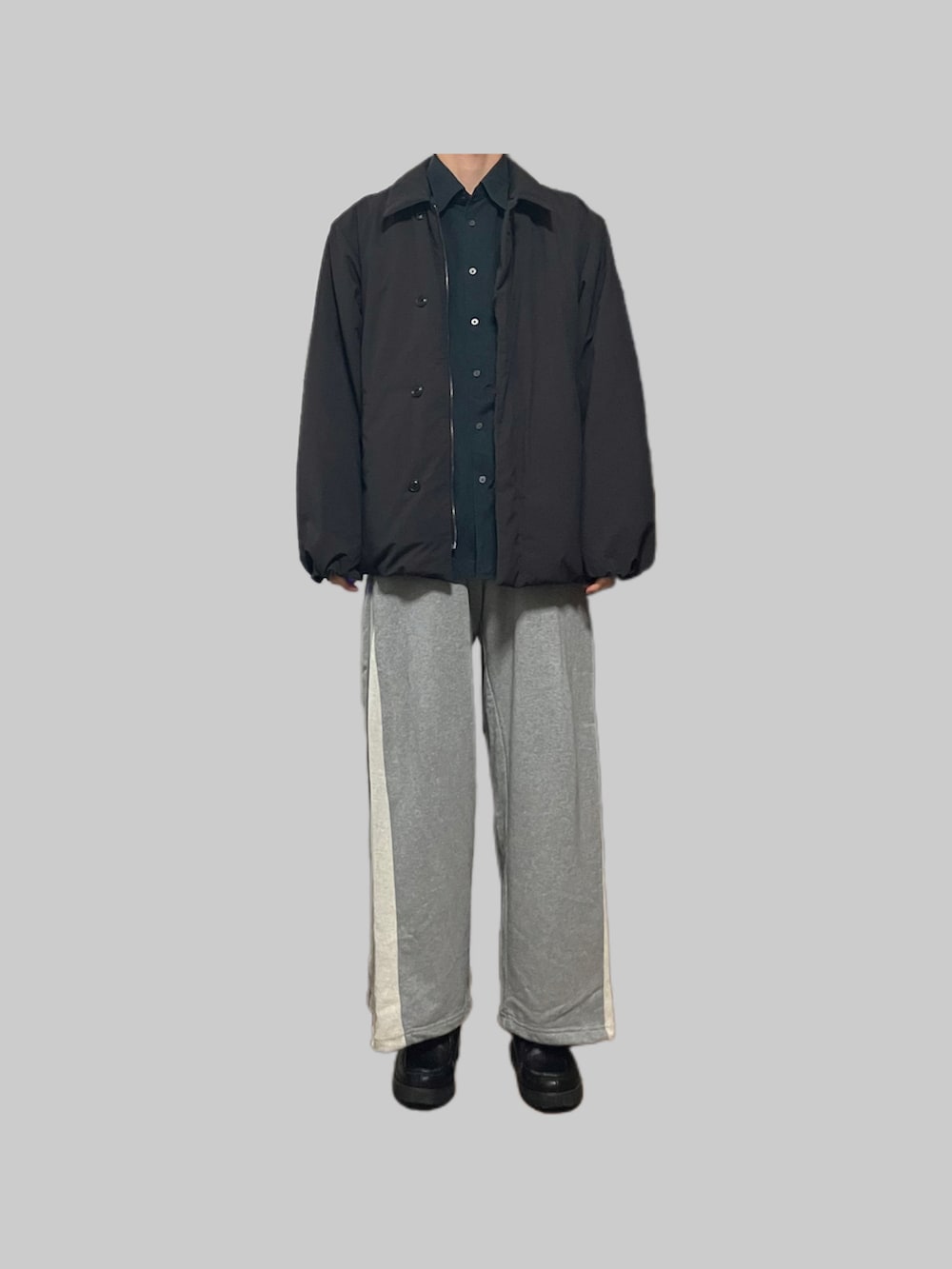 ブラック系のダウンジャケット/コート、グレー系のスウェットパンツ、ブラック系のローファーを着用したメンズの秋コーディネートの3枚目の写真