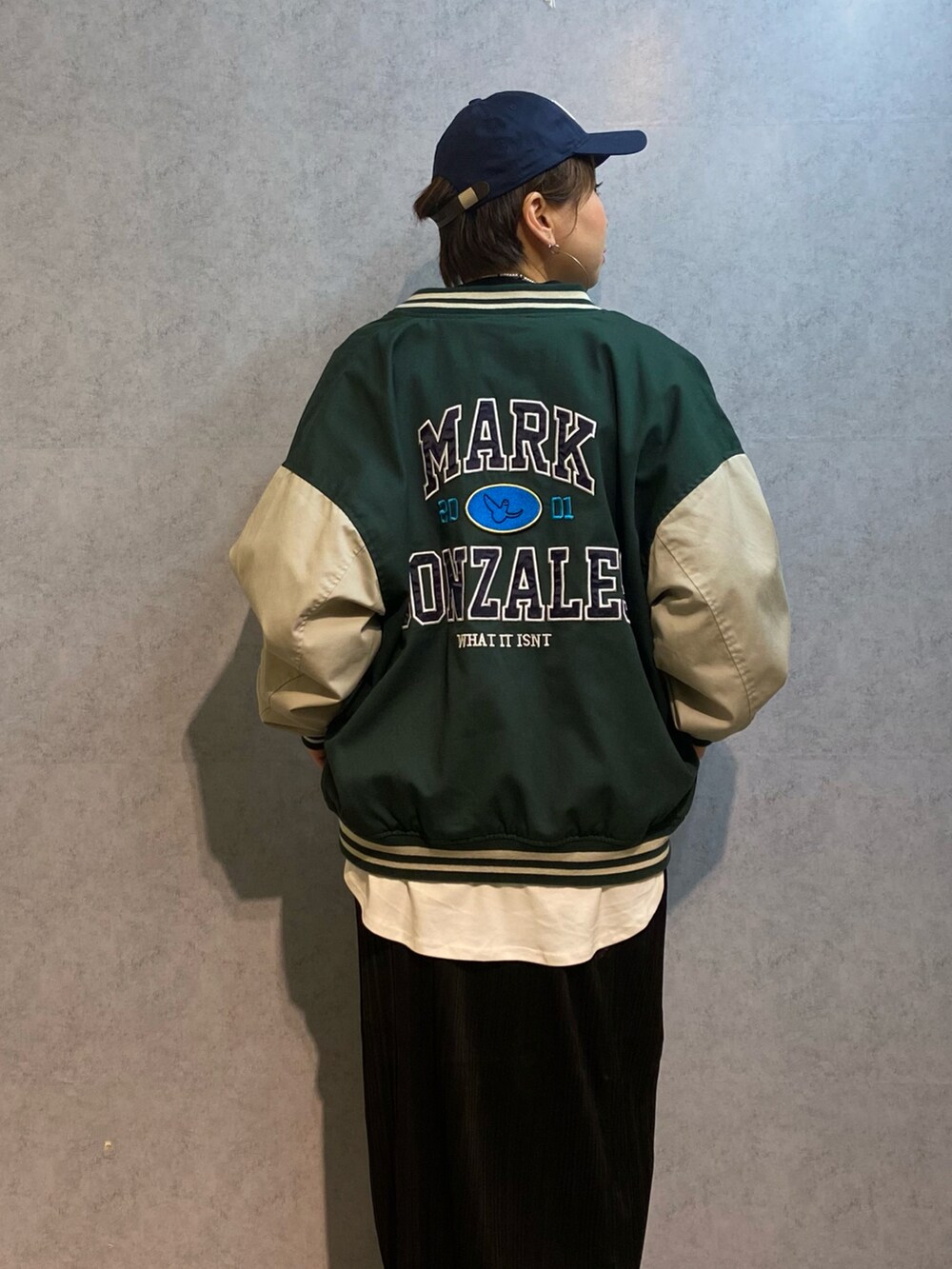 ブラック系のスカート、ブラック系のブーツ、ホワイト系のTシャツ/カットソーを着用したレディースの冬コーディネートの2枚目の写真