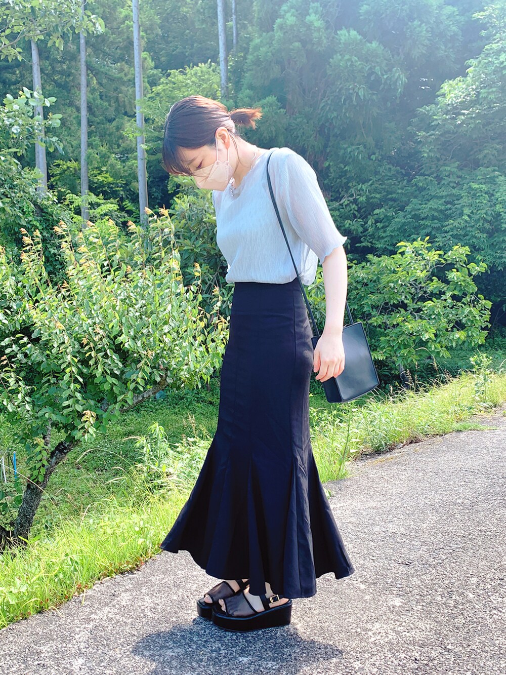 ベージュ系のサンダル、ブラック系のスカート、ブラック系のショルダーバッグを着用したレディースの夏コーディネートの2枚目の写真