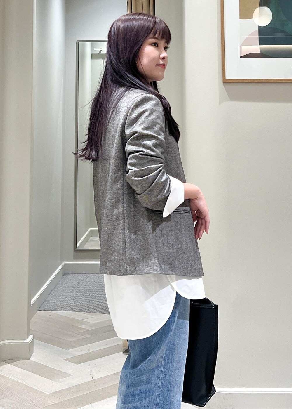 ブラック系のパンプス、ブルー系のデニムパンツ、ブラック系のトートバッグを着用したレディースの秋コーディネートの9枚目の写真