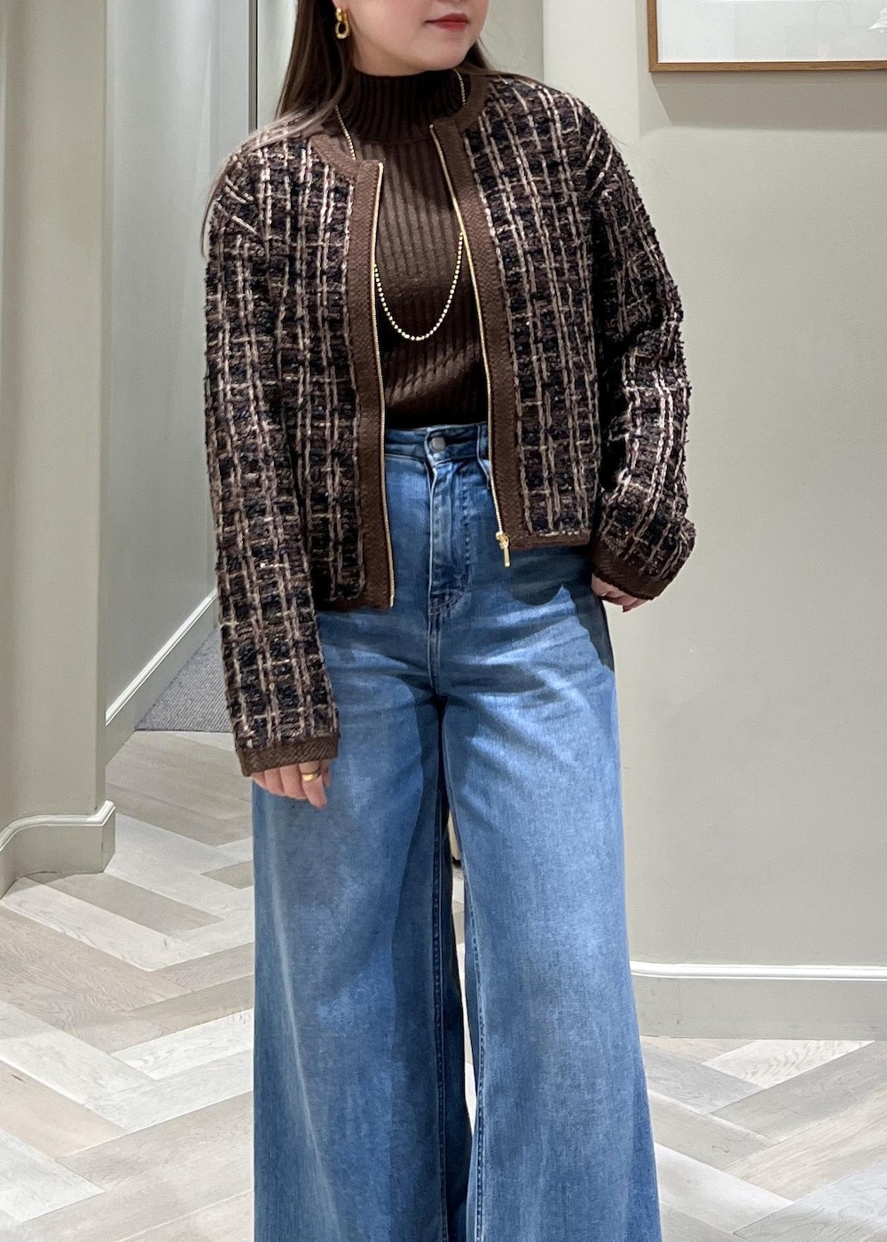 ブルー系のデニムパンツ、ブラック系のブーツ、ブラウン系のニット/セーターを着用したレディースの秋コーディネートの8枚目の写真