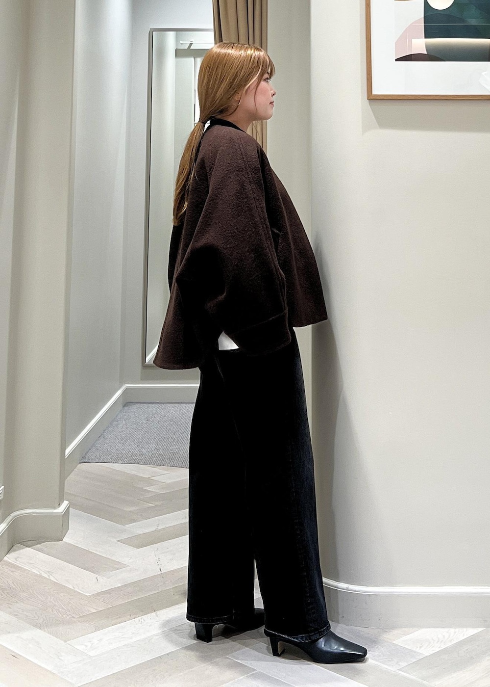 ブラック系のデニムパンツ、ブラック系のブーツ、ブラウン系のブルゾンを着用したレディースの秋コーディネートの3枚目の写真