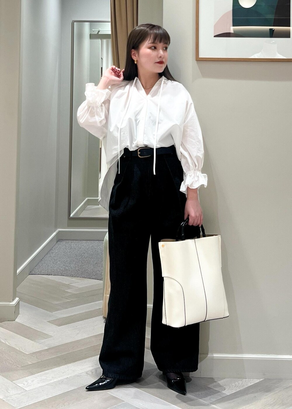 ブラック系のパンプス、ホワイト系のシャツ/ブラウス、ブラック系のデニムパンツを着用したレディースの春コーディネートの5枚目の写真