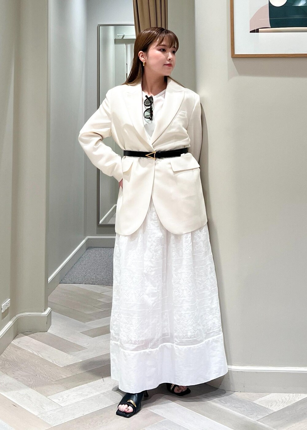 ホワイト系のテーラードジャケット、ブラック系のサンダル、ホワイト系のワンピースを着用したレディースの春コーディネートの5枚目の写真