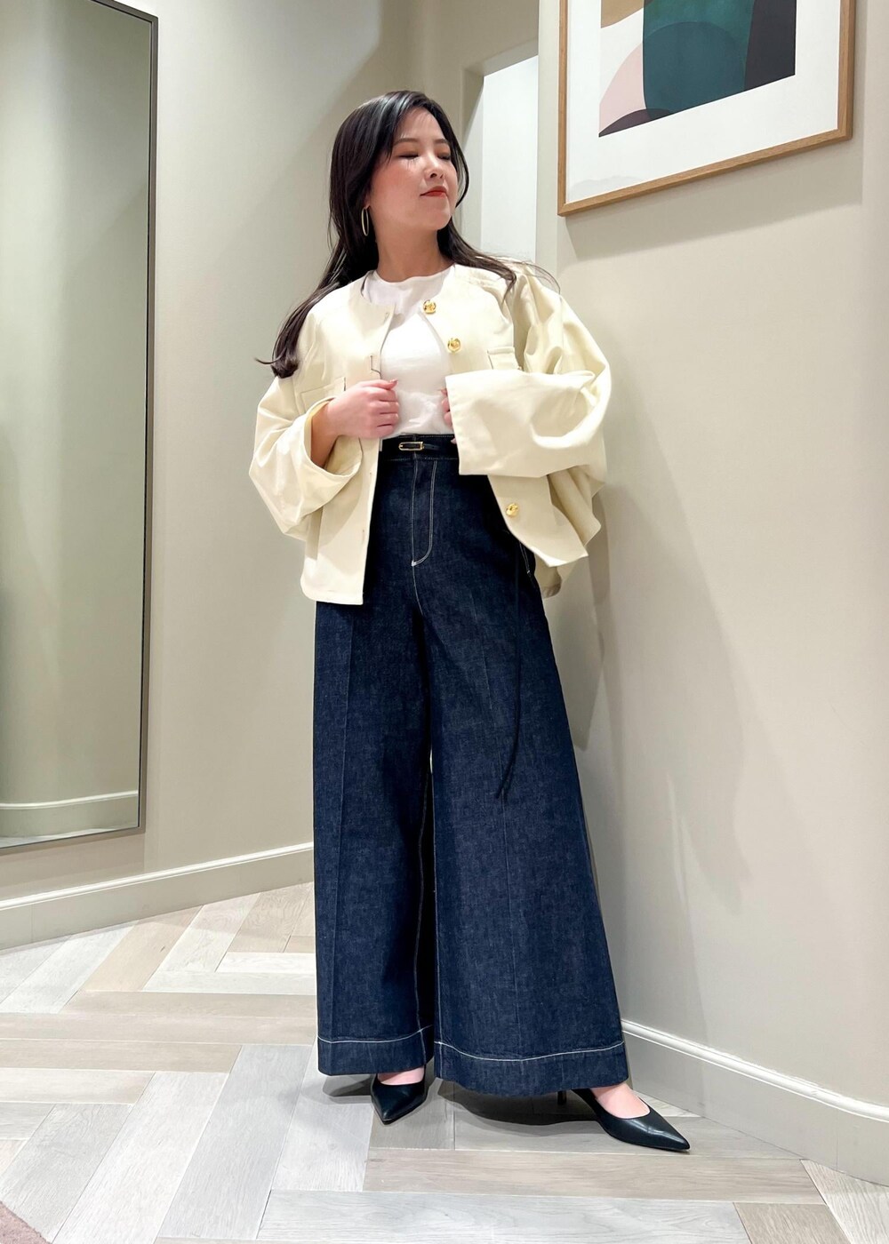 ブラック系のパンプス、ホワイト系のニット/セーター、ブルー系のデニムパンツを着用したレディースの春コーディネートの6枚目の写真