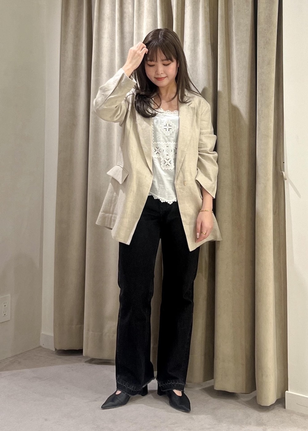 グレー系のデニムパンツ、ブラック系のパンプス、ホワイト系のキャミソールを着用したレディースの春コーディネートの3枚目の写真