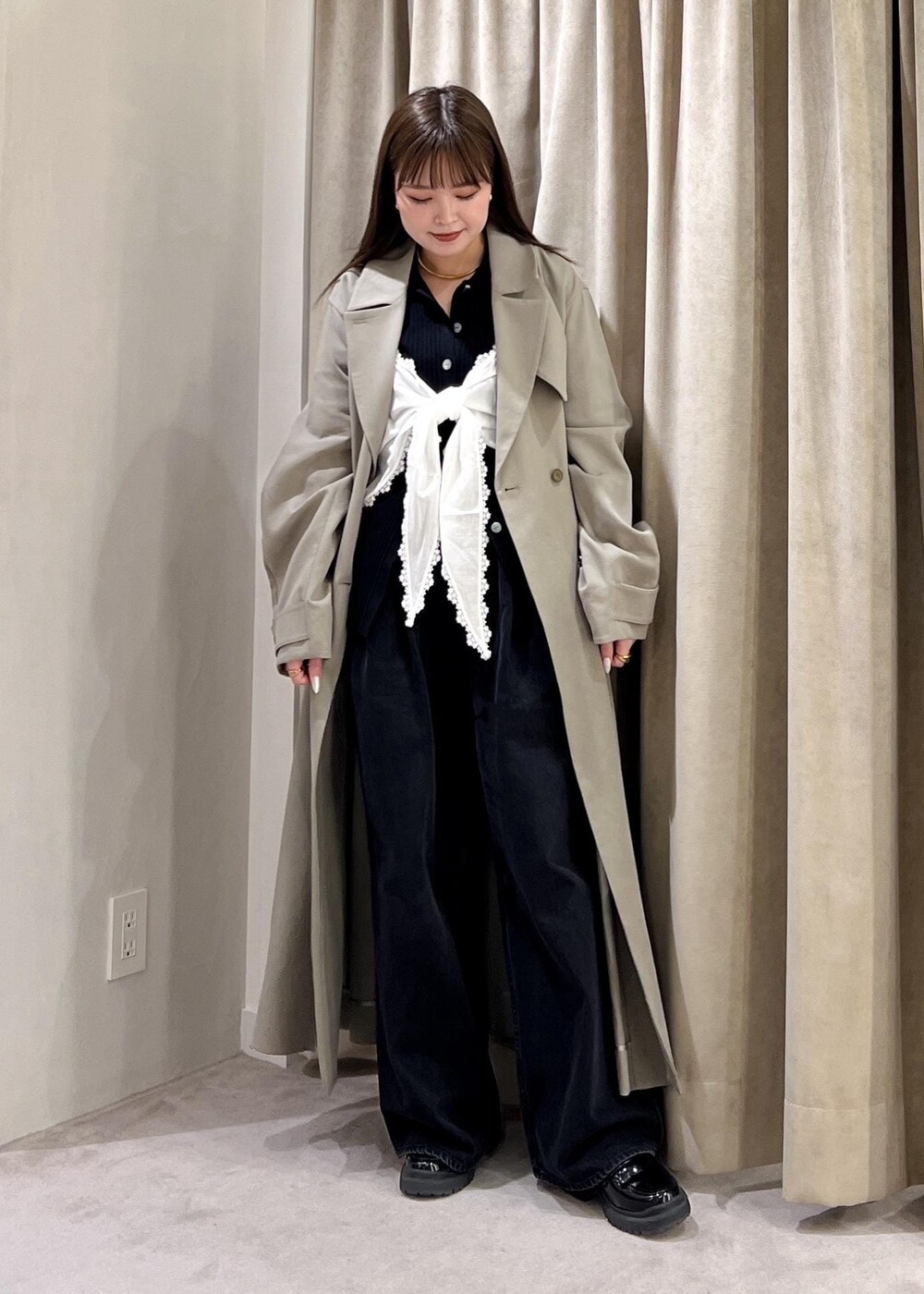 ブラック系のデニムパンツ、ブラック系のカーディガン/ボレロ、ホワイト系のキャミソールを着用したレディースの冬コーディネートの2枚目の写真