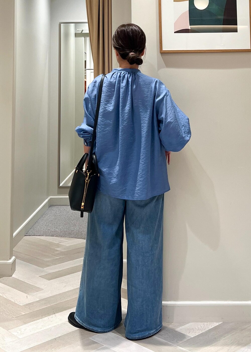 ブラック系のハンドバッグ、ブルー系のデニムパンツ、ブルー系のシャツ/ブラウスを着用したレディースの夏コーディネートの4枚目の写真