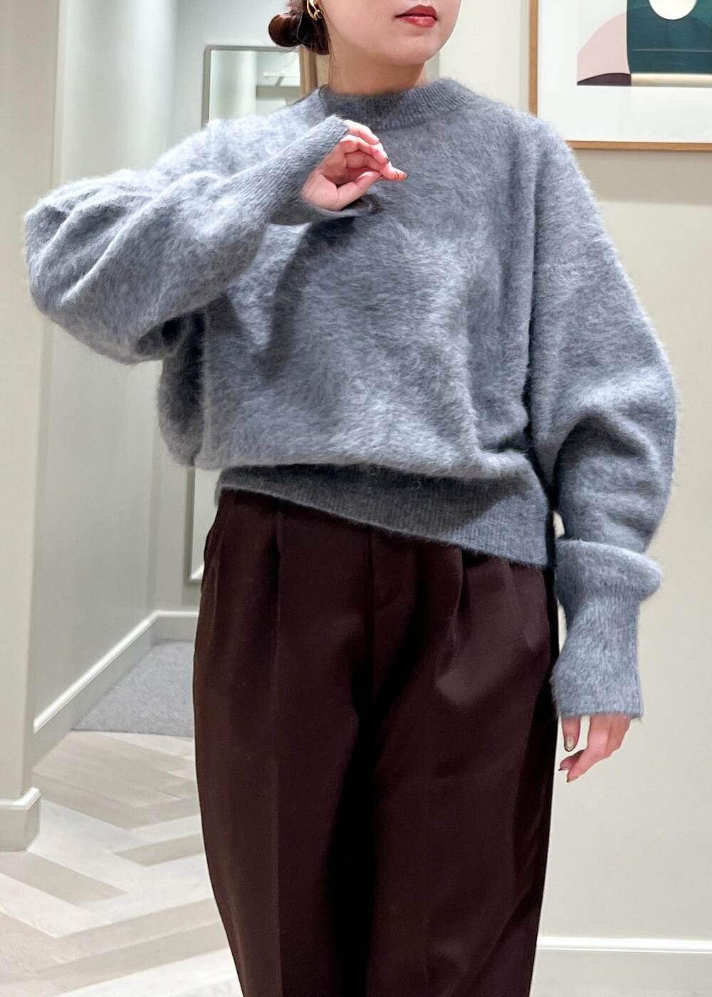 ブラック系のハンドバッグ、ブラック系のブーツ、グレー系のカーディガン/ボレロを着用したレディースの秋コーディネートの5枚目の写真