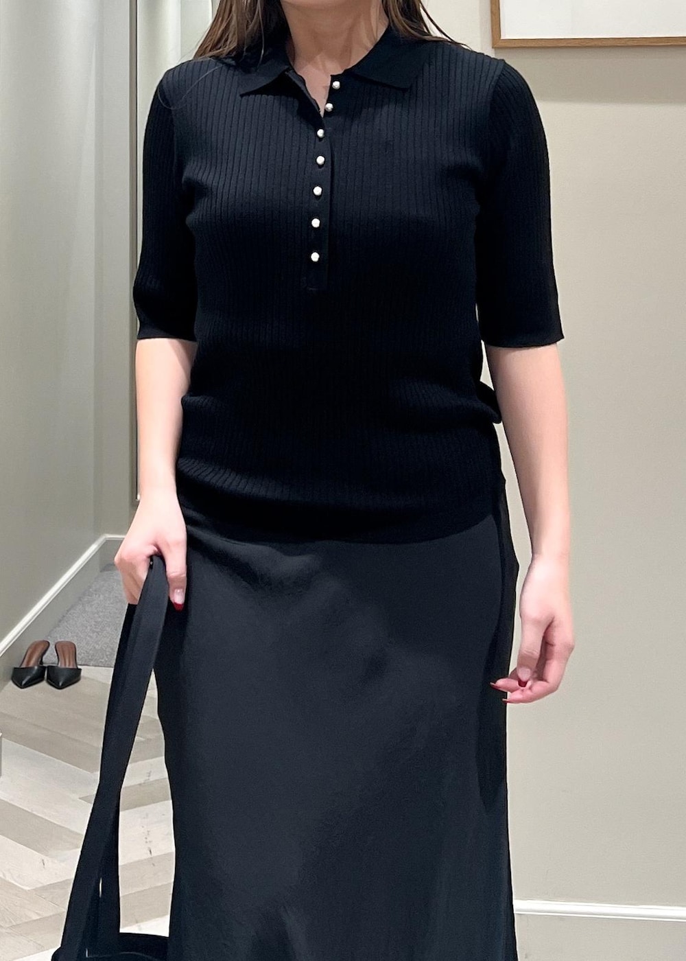 ブラック系のパンプス、ブラック系のスカート、ブラック系のニット/セーターを着用したレディースの秋コーディネートの6枚目の写真