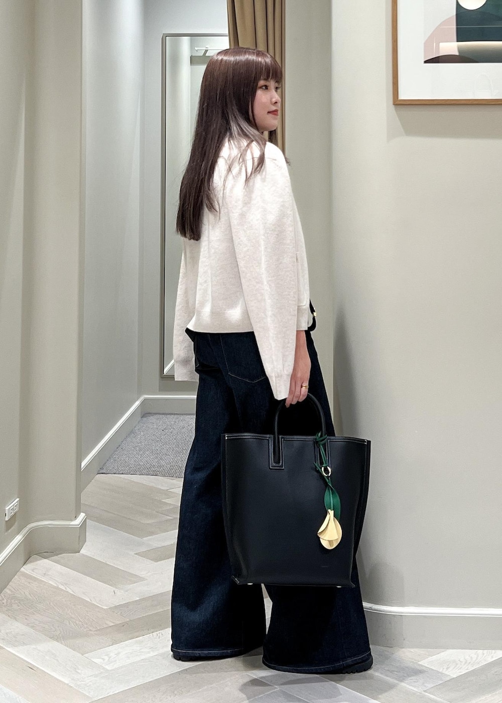 ベージュ系のカーディガン/ボレロ、ベージュ系のニット/セーター、ブルー系のデニムパンツを着用したレディースの秋コーディネートの3枚目の写真