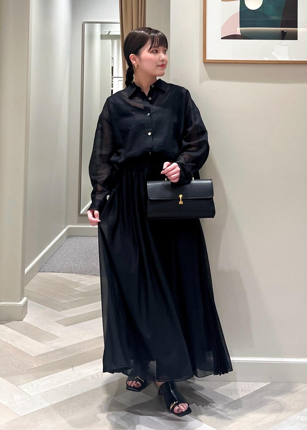 ブラック系のサンダル、ブラック系のショルダーバッグ、ブラック系のシャツ/ブラウスを着用したレディースの春コーディネートの5枚目の写真