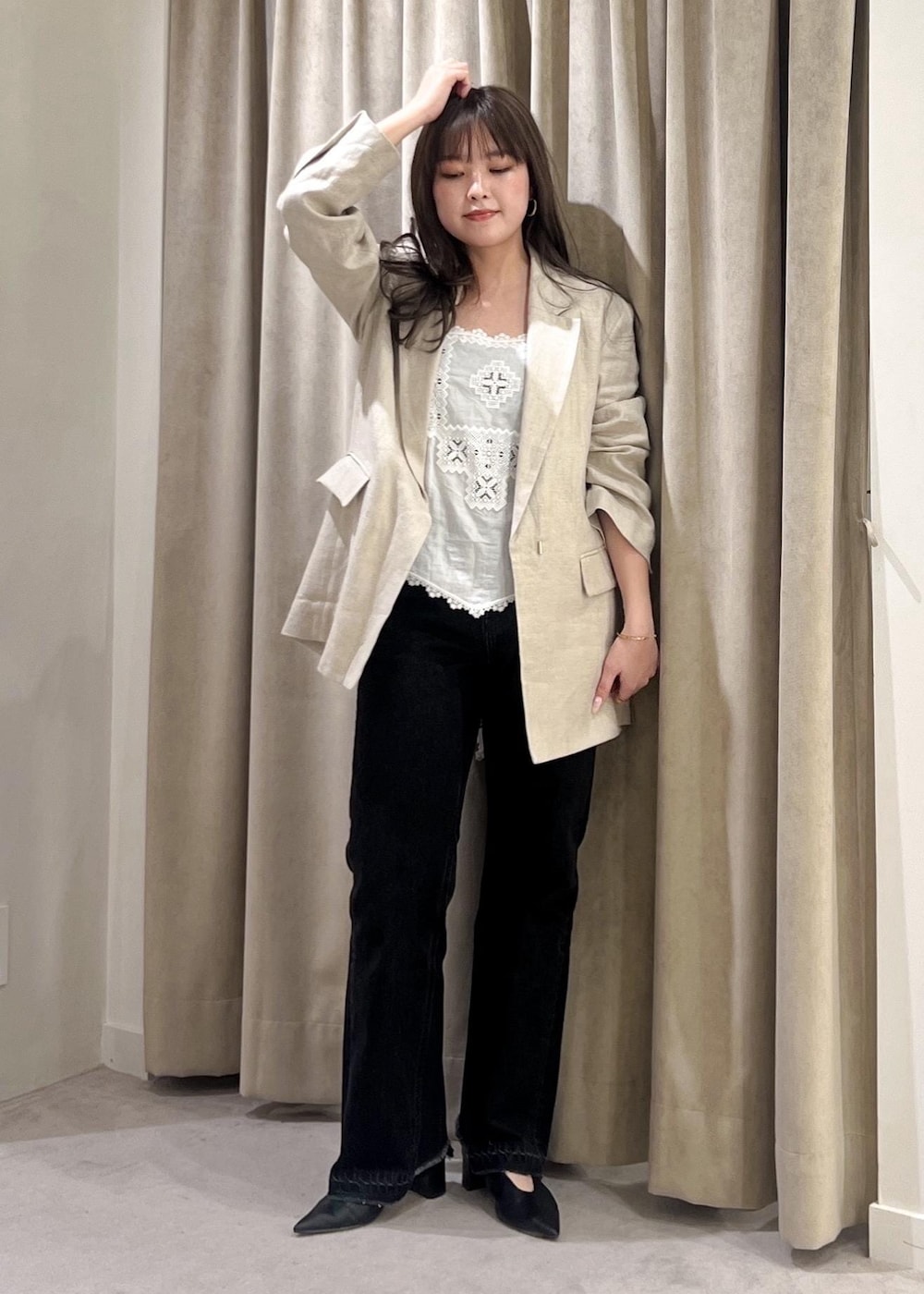 グレー系のデニムパンツ、ブラック系のパンプス、ホワイト系のキャミソールを着用したレディースの春コーディネートの6枚目の写真