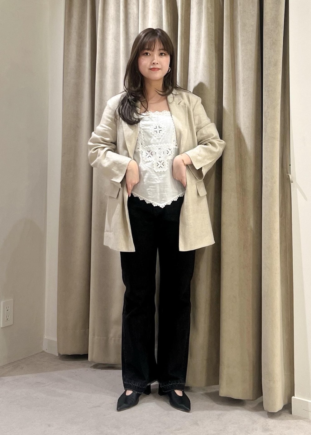 グレー系のデニムパンツ、ブラック系のパンプス、ホワイト系のキャミソールを着用したレディースの春コーディネートの2枚目の写真