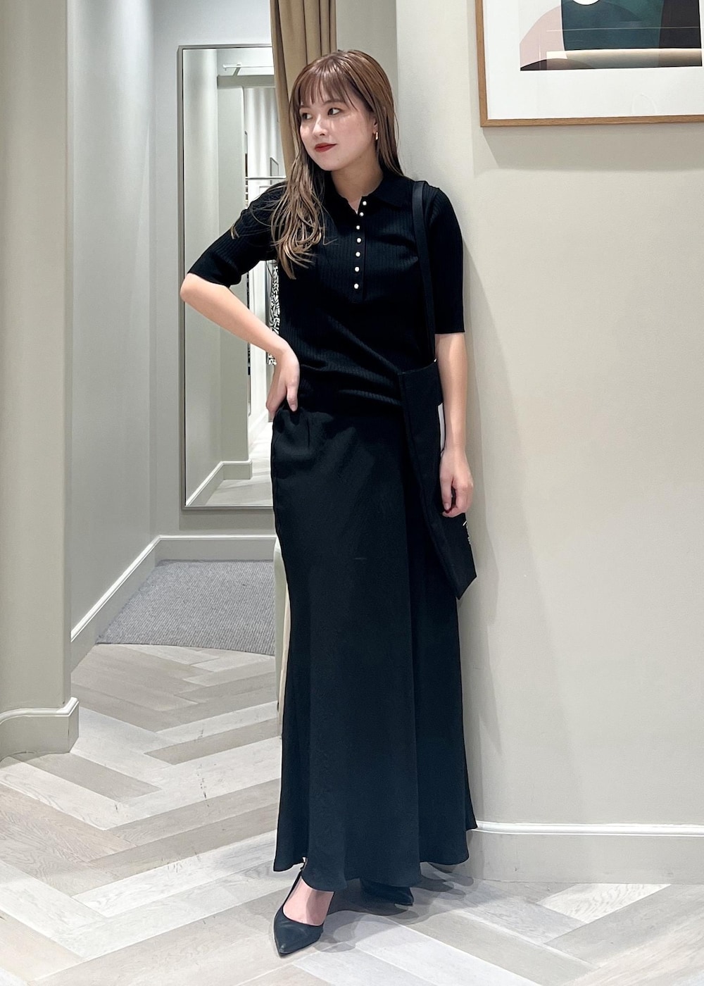 ブラック系のパンプス、ブラック系のスカート、ブラック系のニット/セーターを着用したレディースの秋コーディネートの2枚目の写真