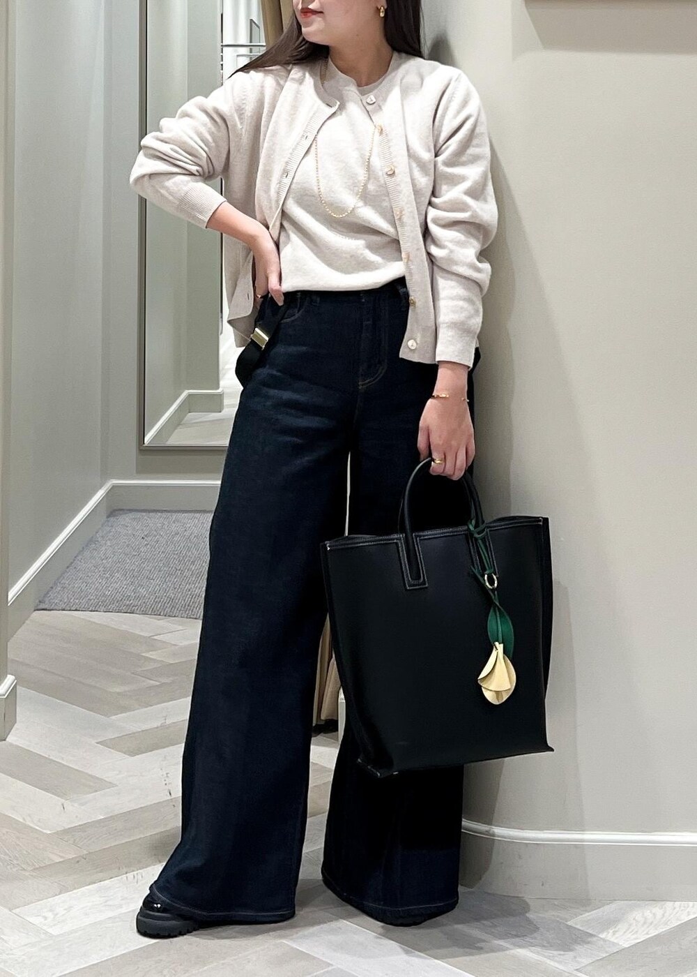 ベージュ系のカーディガン/ボレロ、ベージュ系のニット/セーター、ブルー系のデニムパンツを着用したレディースの秋コーディネートの7枚目の写真