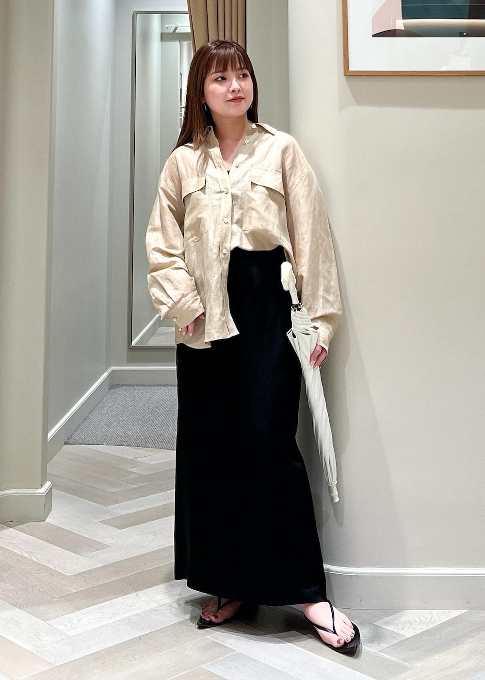 ブラック系のスカート、ベージュ系のシャツ/ブラウス、ホワイト系の長傘を着用したレディースの夏コーディネートの5枚目の写真