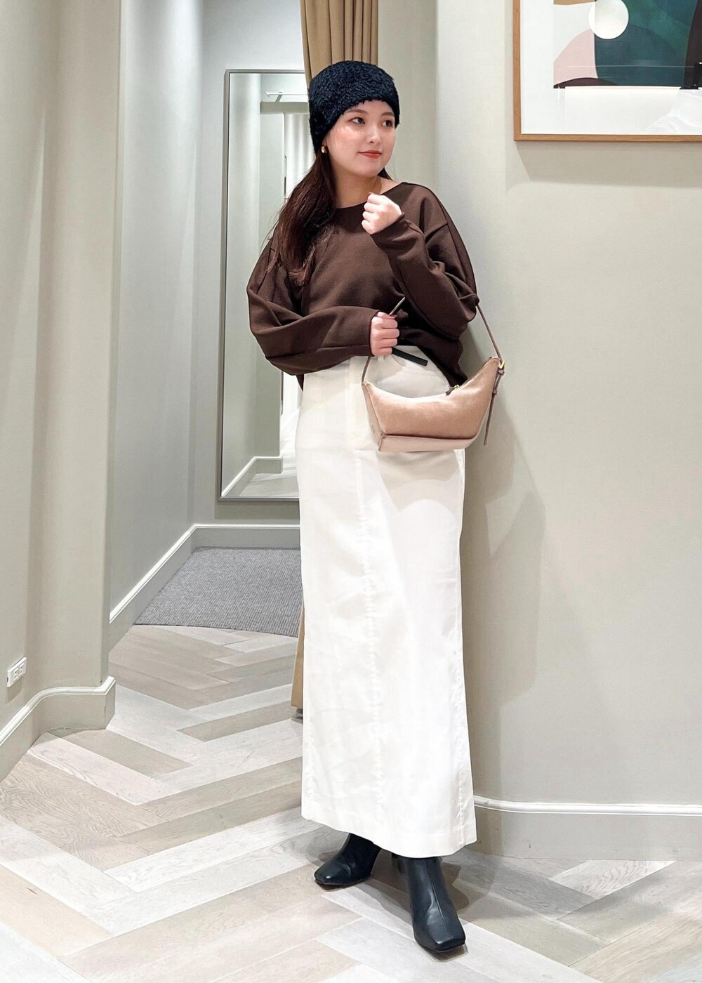 ブラック系のブーツ、ホワイト系のスカート、ブラウン系のTシャツ/カットソーを着用したレディースの秋コーディネートの5枚目の写真