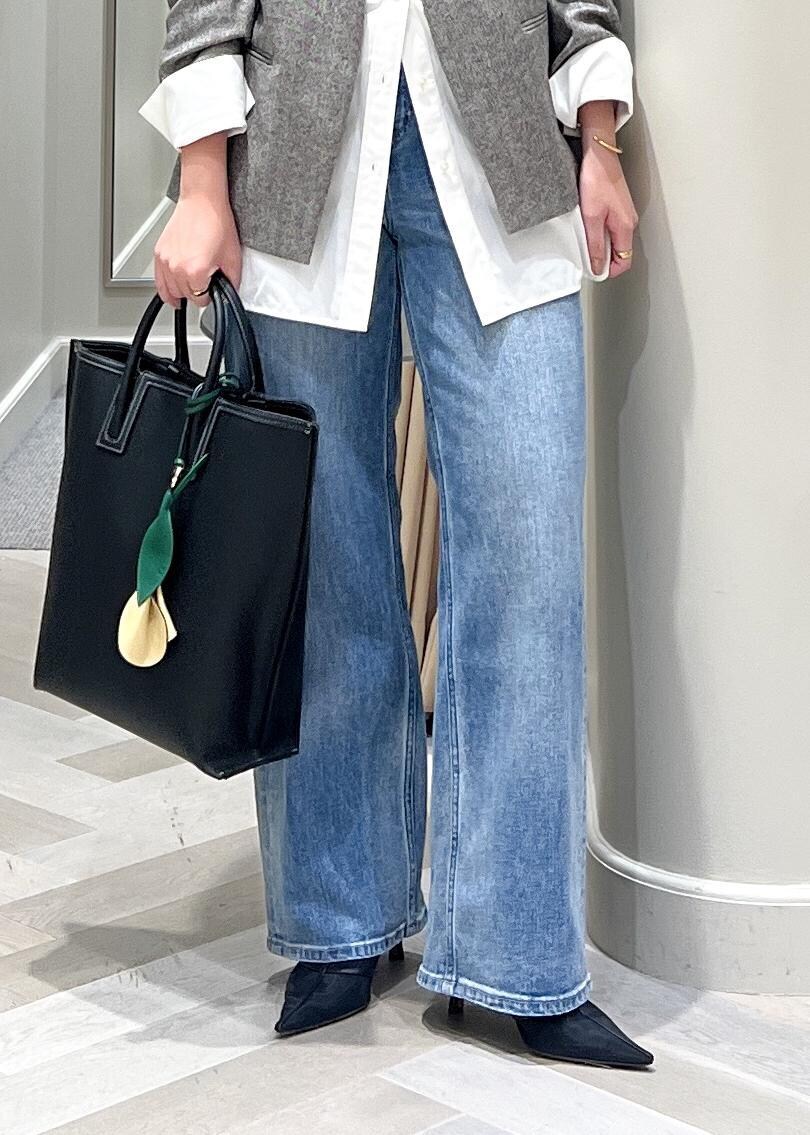 ブラック系のパンプス、ブルー系のデニムパンツ、ブラック系のトートバッグを着用したレディースの秋コーディネートの10枚目の写真