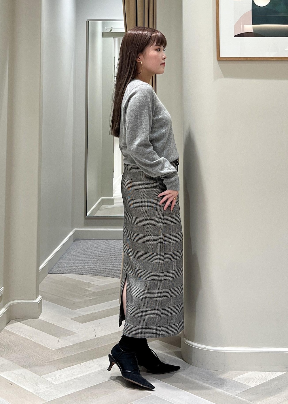ブラック系のパンプス、ブラック系のスカート、グレー系のニット/セーターを着用したレディースの秋コーディネートの5枚目の写真
