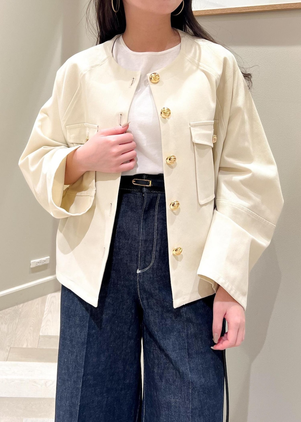 ブラック系のパンプス、ホワイト系のニット/セーター、ブルー系のデニムパンツを着用したレディースの春コーディネートの8枚目の写真