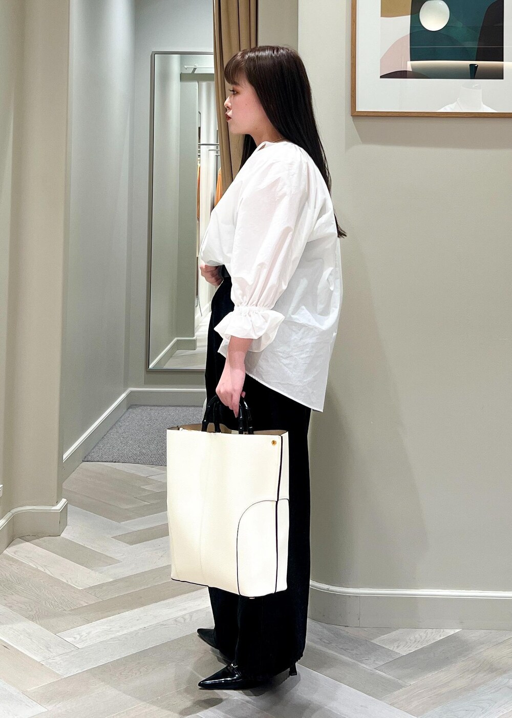 ブラック系のパンプス、ホワイト系のシャツ/ブラウス、ブラック系のデニムパンツを着用したレディースの春コーディネートの3枚目の写真