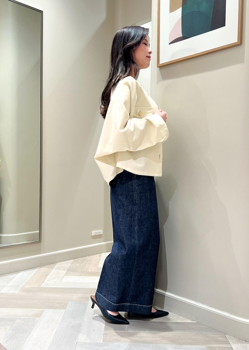 ブラック系のパンプス、ホワイト系のニット/セーター、ブルー系のデニムパンツを着用したレディースの春コーディネートの3枚目の写真