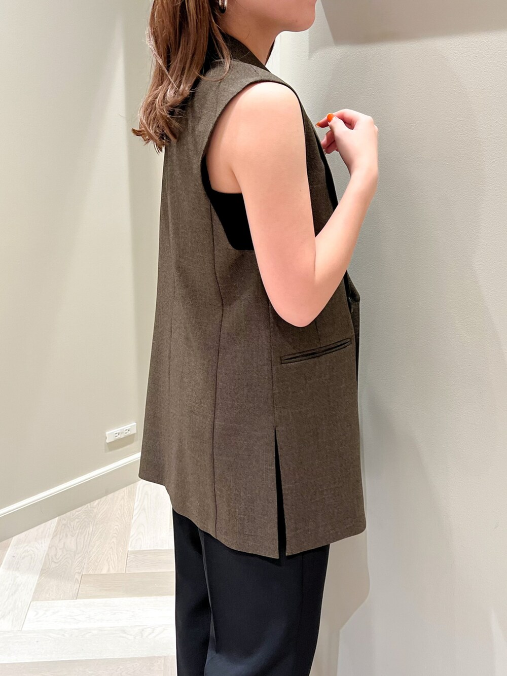 ブラウン系のベスト、レッド系のハンドバッグ、ブラック系のその他パンツを着用したレディースの夏コーディネートの3枚目の写真