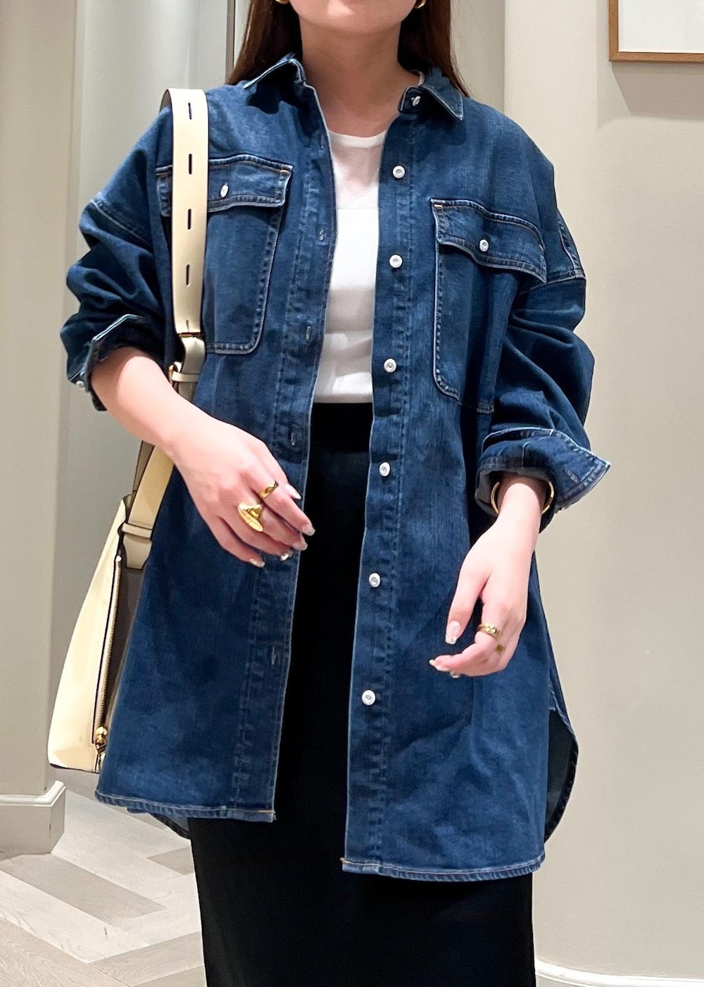 ホワイト系のショルダーバッグ、ブラック系のパンプス、ブラック系のスカートを着用したレディースの夏コーディネートの7枚目の写真