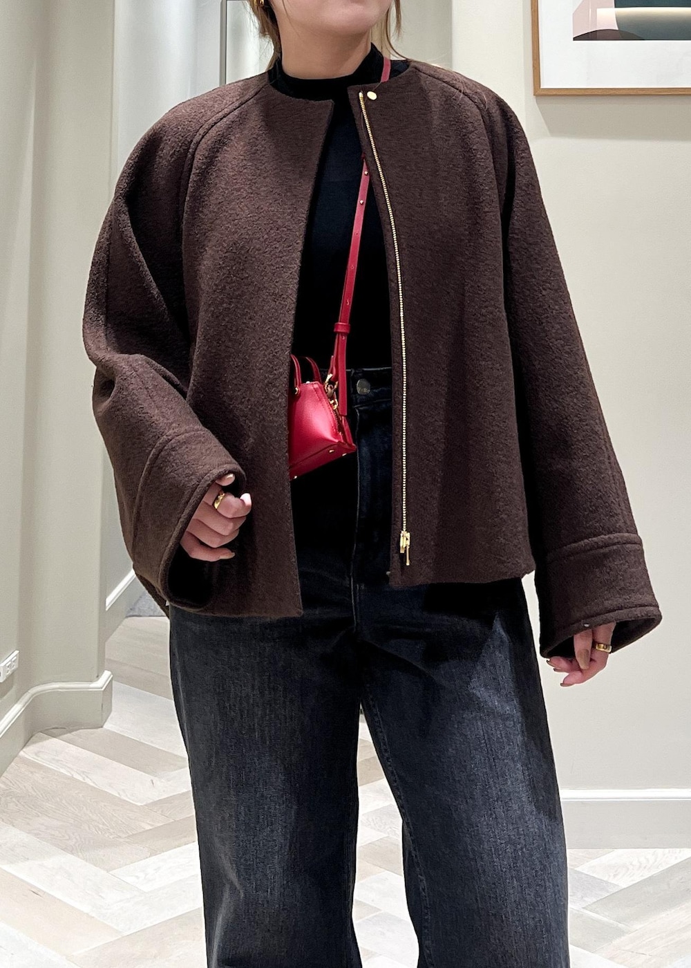 ブラック系のデニムパンツ、ブラック系のブーツ、ブラウン系のブルゾンを着用したレディースの秋コーディネートの6枚目の写真