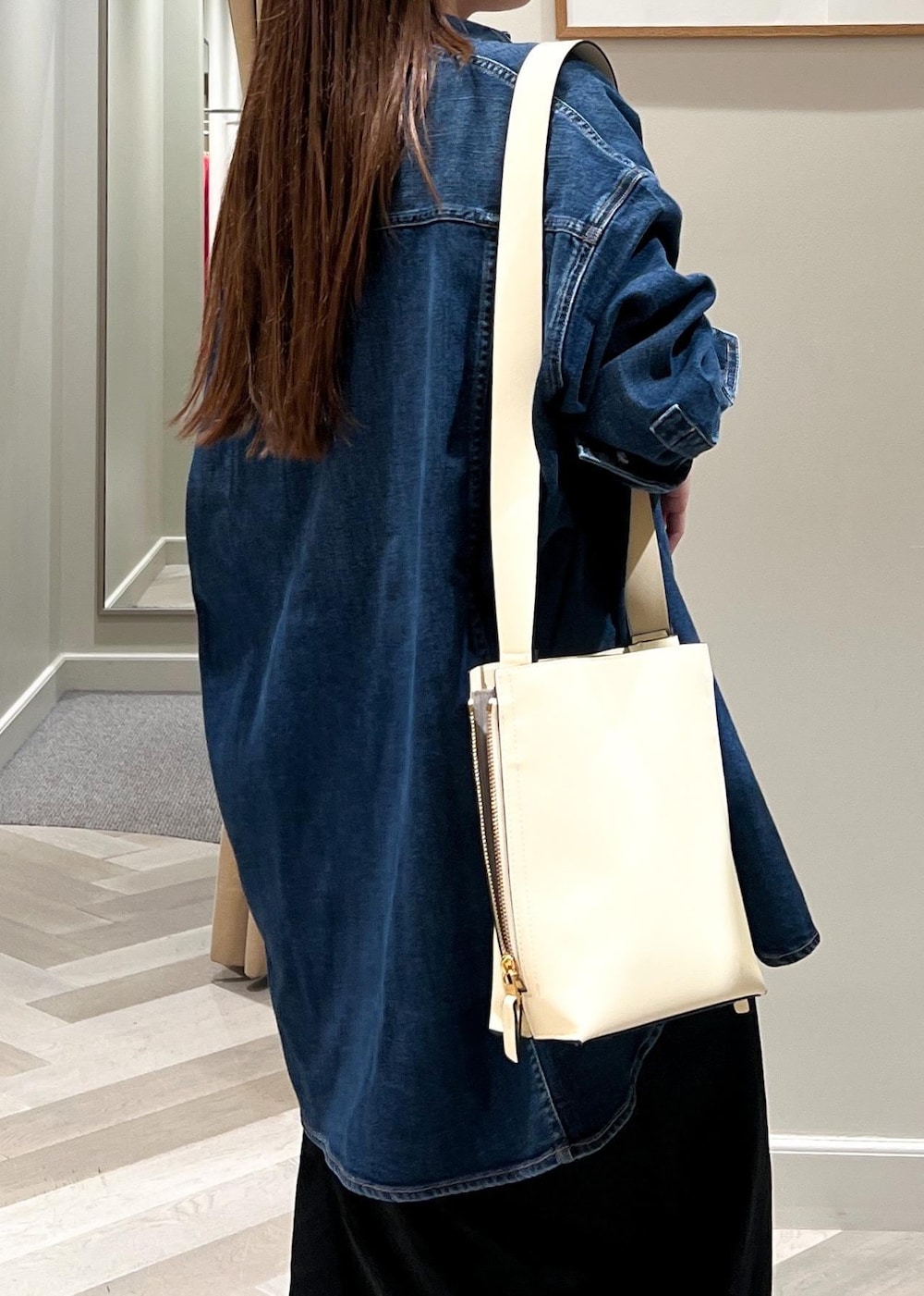 ホワイト系のショルダーバッグ、ブラック系のパンプス、ブラック系のスカートを着用したレディースの夏コーディネートの8枚目の写真