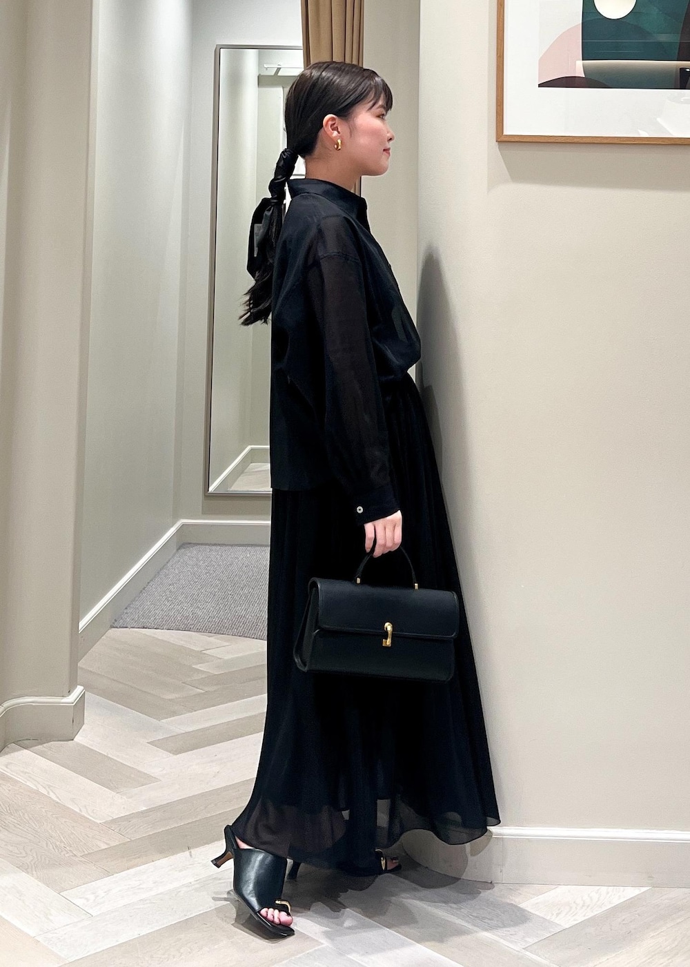 ブラック系のサンダル、ブラック系のショルダーバッグ、ブラック系のシャツ/ブラウスを着用したレディースの春コーディネートの3枚目の写真