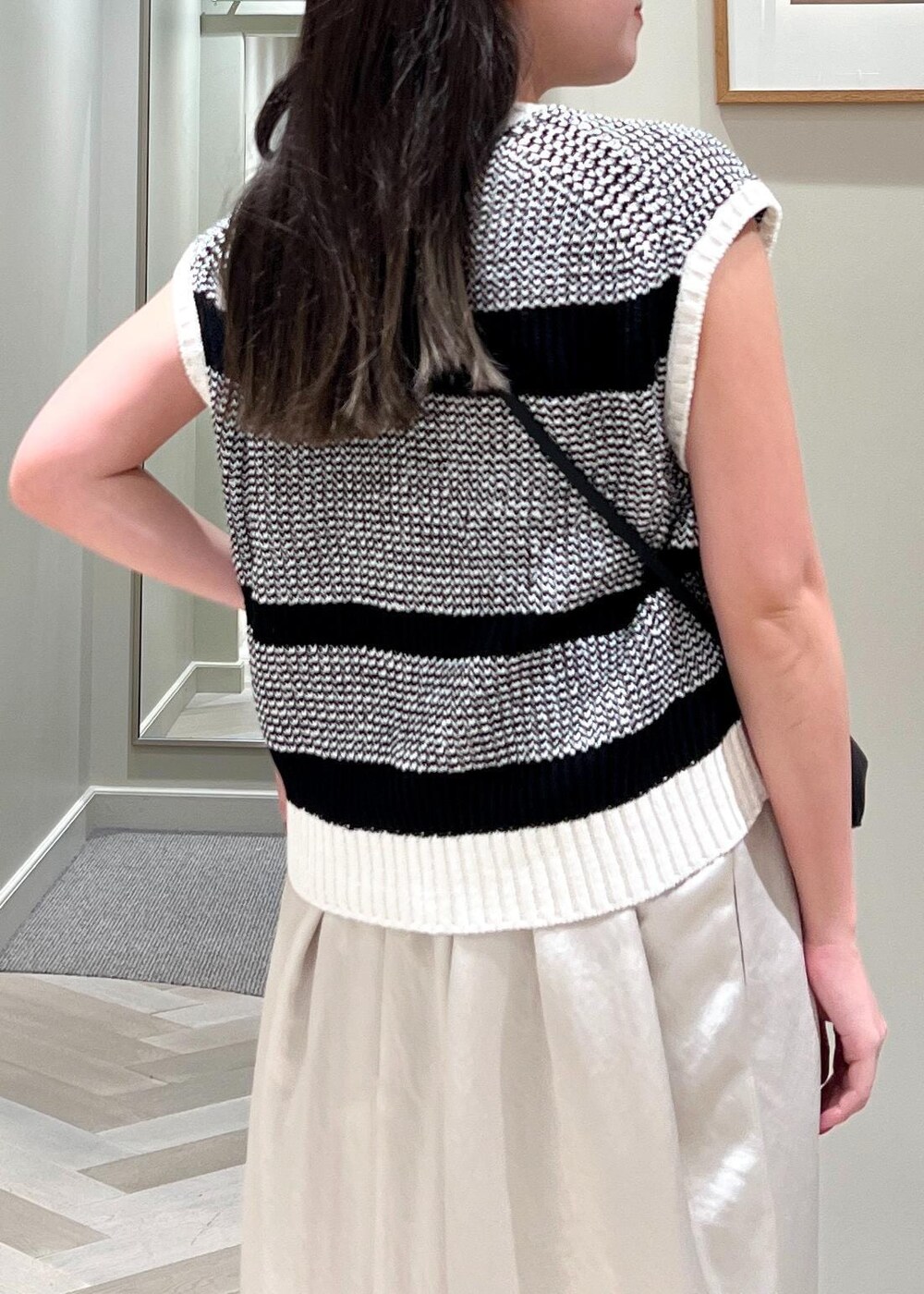 ブラック系のパンプス、ブラック系のショルダーバッグ、ベージュ系のワンピースを着用したレディースの夏コーディネートの7枚目の写真