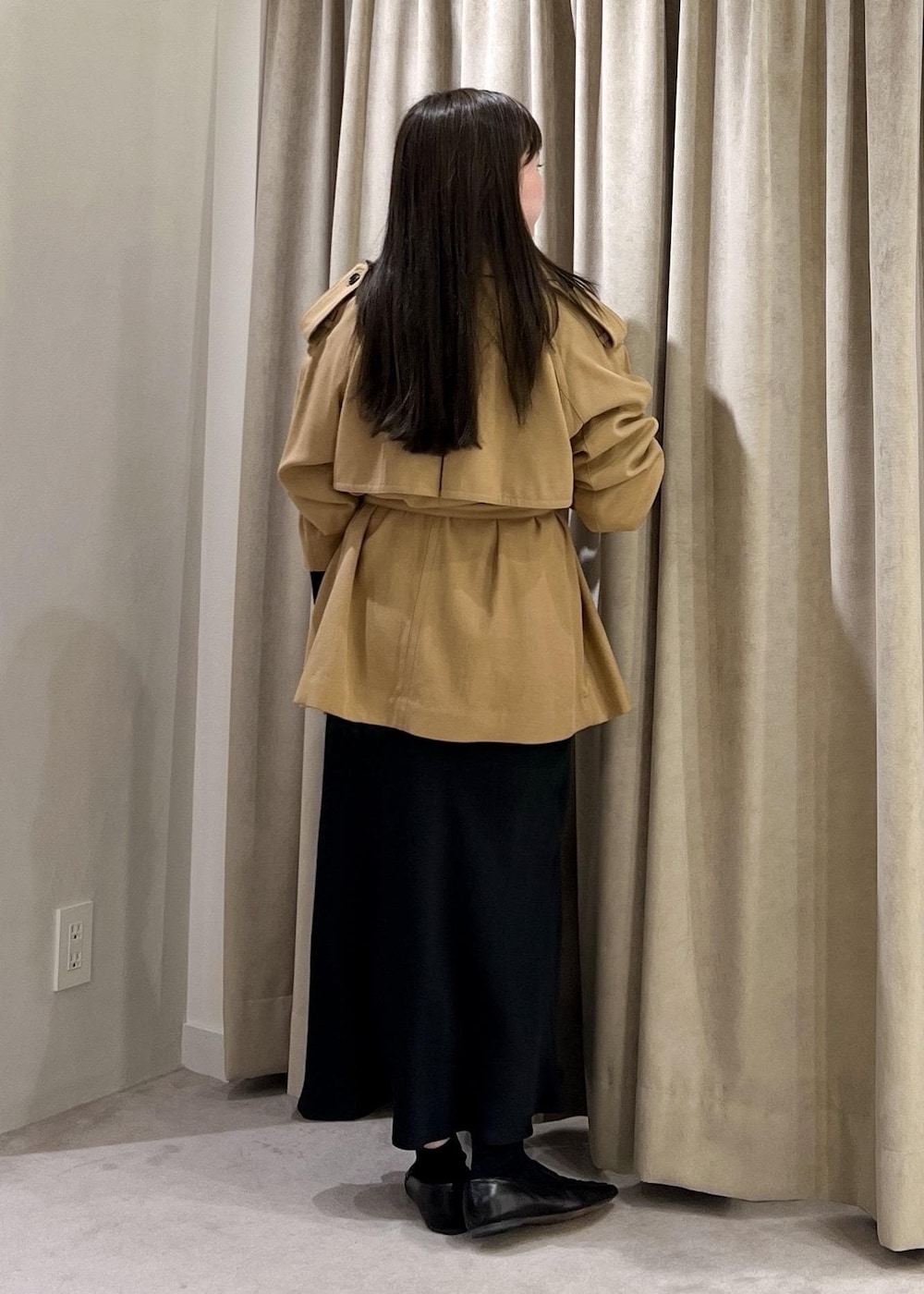 ブラック系のスカート、ベージュ系のトレンチコート、ホワイト系のニット/セーターを着用したレディースの冬コーディネートの7枚目の写真