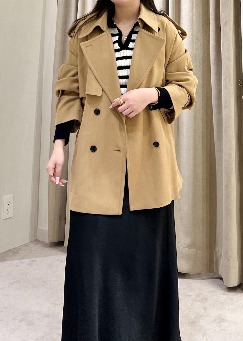 ブラック系のスカート、ベージュ系のトレンチコート、ホワイト系のニット/セーターを着用したレディースの冬コーディネートの10枚目の写真