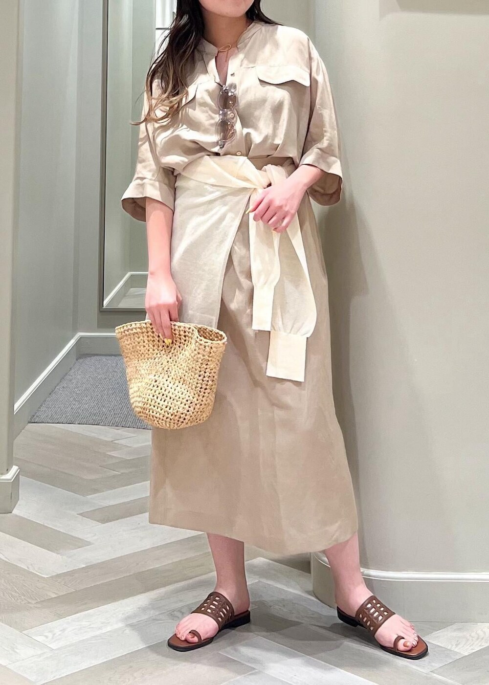 イエロー系のサンダル、ベージュ系のワンピース、ホワイト系のカーディガン/ボレロを着用したレディースの夏コーディネートの6枚目の写真