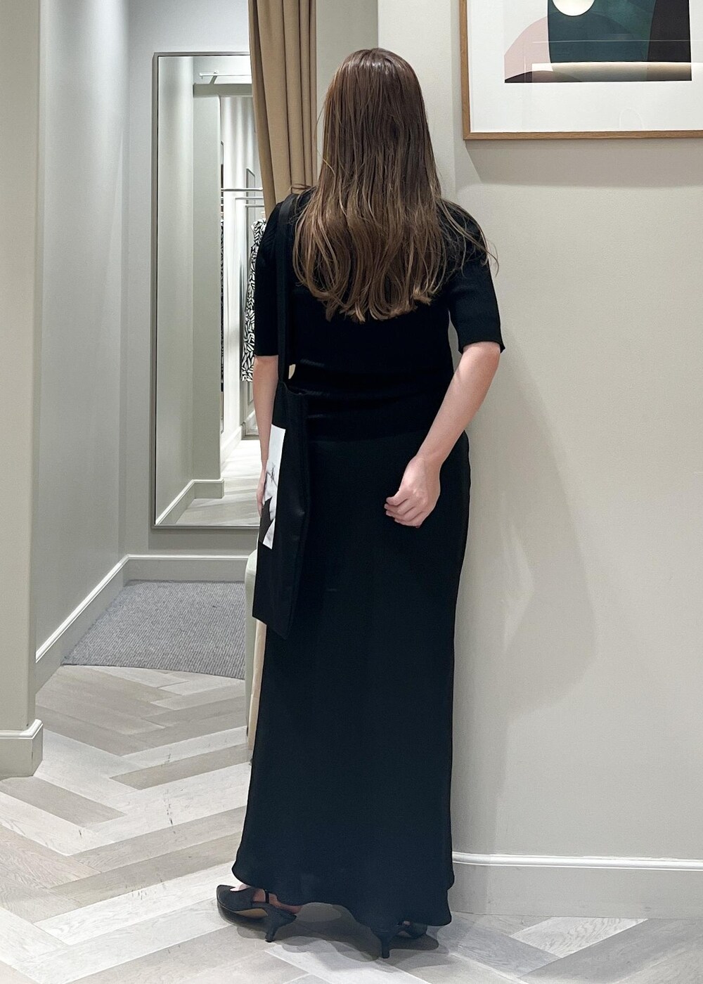 ブラック系のパンプス、ブラック系のスカート、ブラック系のニット/セーターを着用したレディースの秋コーディネートの4枚目の写真