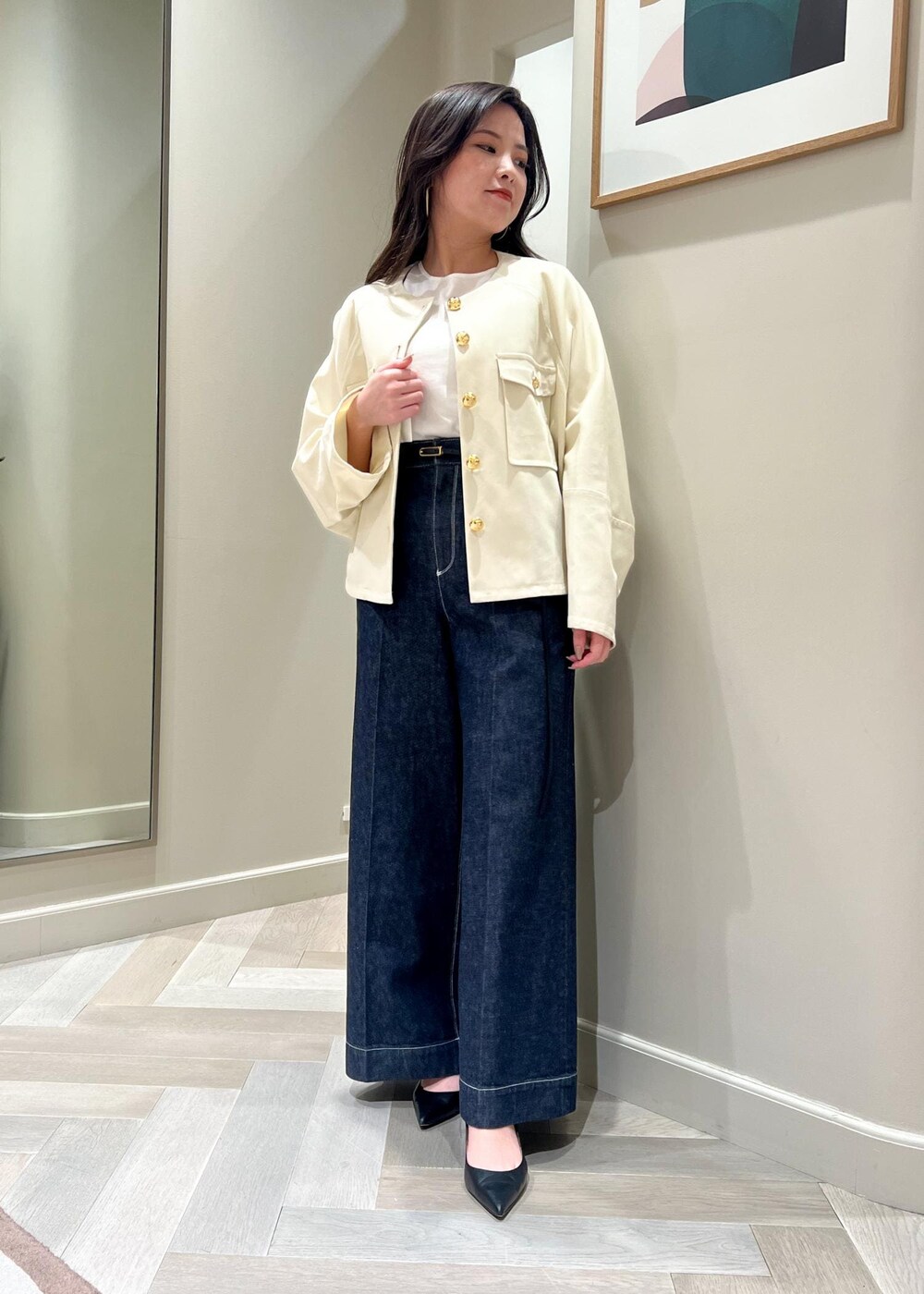 ブラック系のパンプス、ホワイト系のニット/セーター、ブルー系のデニムパンツを着用したレディースの春コーディネートの5枚目の写真