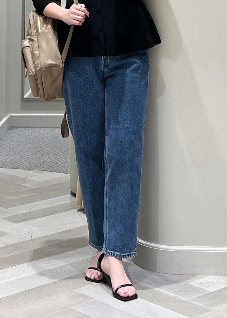 ブラック系のニット/セーター、ベージュ系のバックパック/リュック、ブルー系のデニムパンツを着用したレディースの冬コーディネートの9枚目の写真