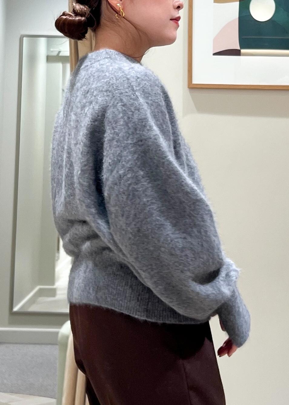 ブラック系のハンドバッグ、ブラック系のブーツ、グレー系のカーディガン/ボレロを着用したレディースの秋コーディネートの6枚目の写真