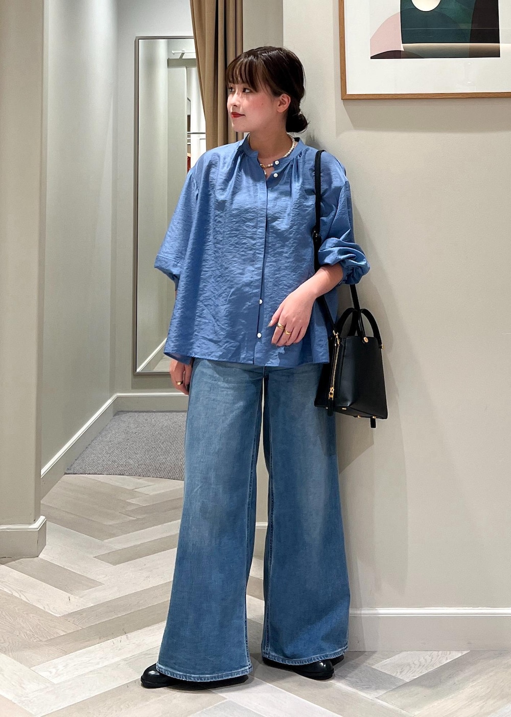 ブラック系のハンドバッグ、ブルー系のデニムパンツ、ブルー系のシャツ/ブラウスを着用したレディースの夏コーディネートの2枚目の写真