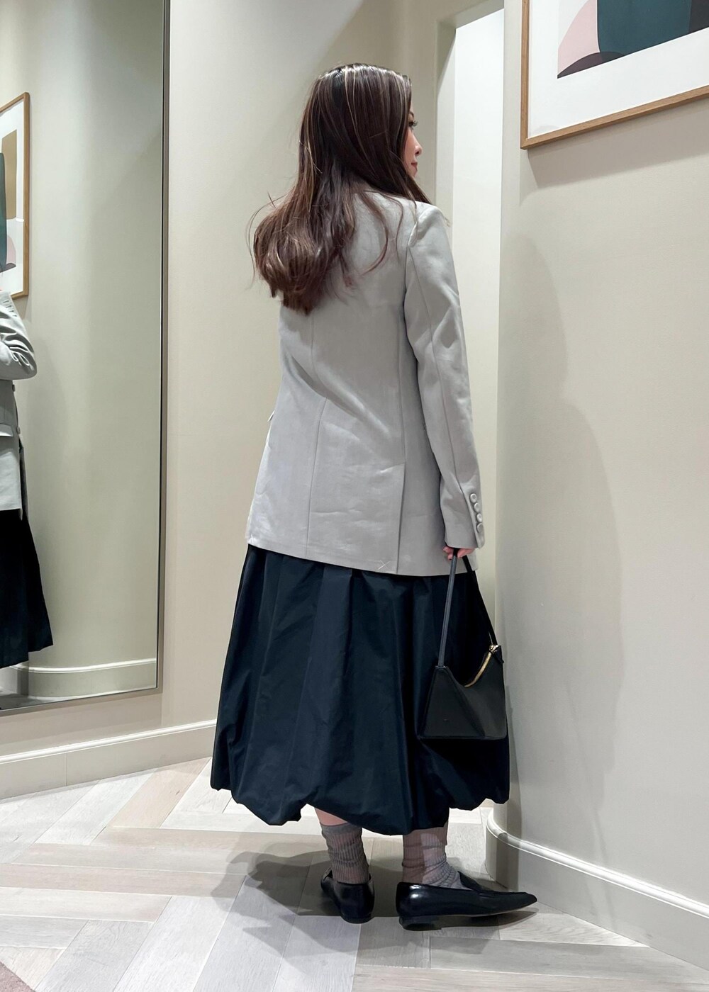 ブラック系のハンドバッグ、ブラック系のパンプス、ブラック系のTシャツ/カットソーを着用したレディースの冬コーディネートの4枚目の写真