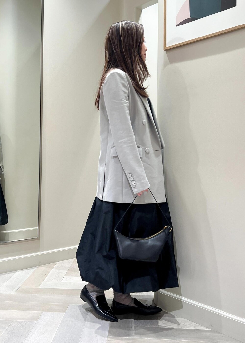ブラック系のハンドバッグ、ブラック系のパンプス、ブラック系のTシャツ/カットソーを着用したレディースの冬コーディネートの3枚目の写真