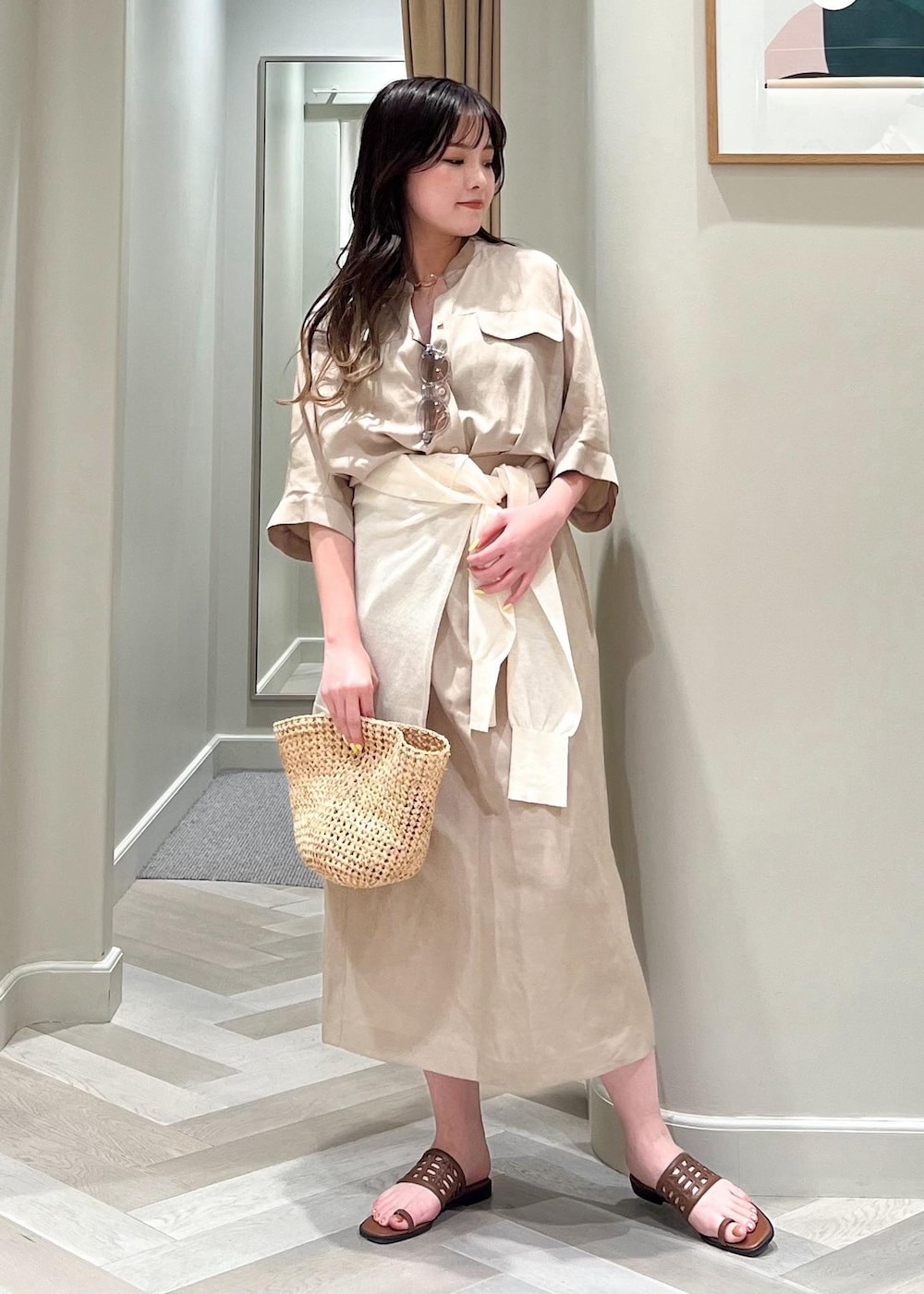 イエロー系のサンダル、ベージュ系のワンピース、ホワイト系のカーディガン/ボレロを着用したレディースの夏コーディネートの2枚目の写真