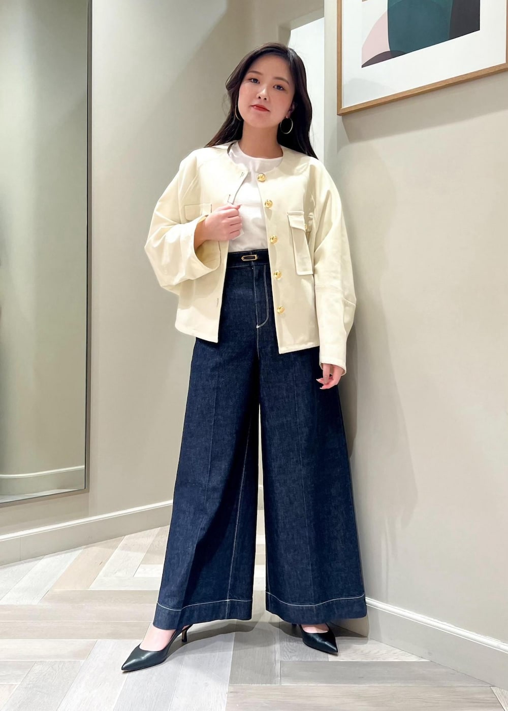 ブラック系のパンプス、ホワイト系のニット/セーター、ブルー系のデニムパンツを着用したレディースの春コーディネートの2枚目の写真