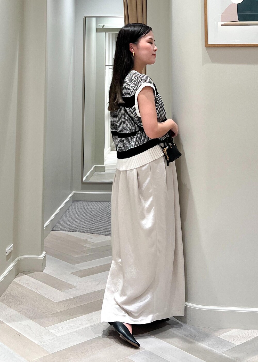 ブラック系のパンプス、ブラック系のショルダーバッグ、ベージュ系のワンピースを着用したレディースの夏コーディネートの3枚目の写真