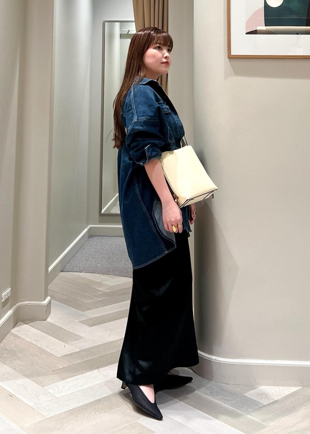 ホワイト系のショルダーバッグ、ブラック系のパンプス、ブラック系のスカートを着用したレディースの夏コーディネートの4枚目の写真