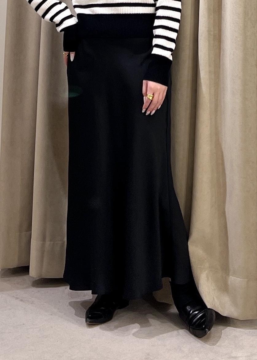 ブラック系のスカート、ベージュ系のトレンチコート、ホワイト系のニット/セーターを着用したレディースの冬コーディネートの4枚目の写真