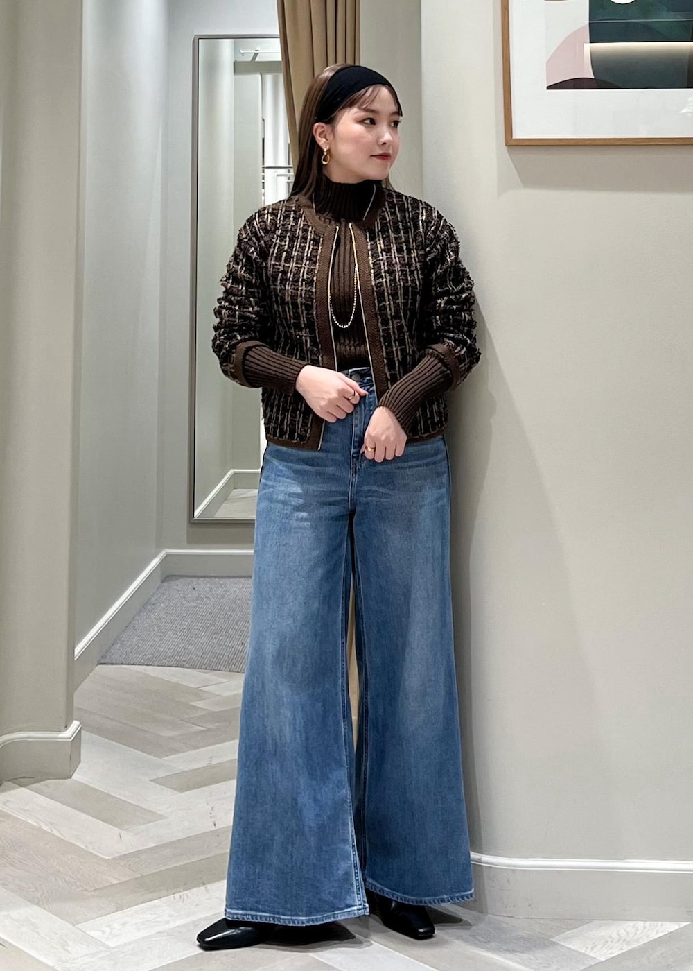 ブルー系のデニムパンツ、ブラック系のブーツ、ブラウン系のニット/セーターを着用したレディースの秋コーディネートの7枚目の写真