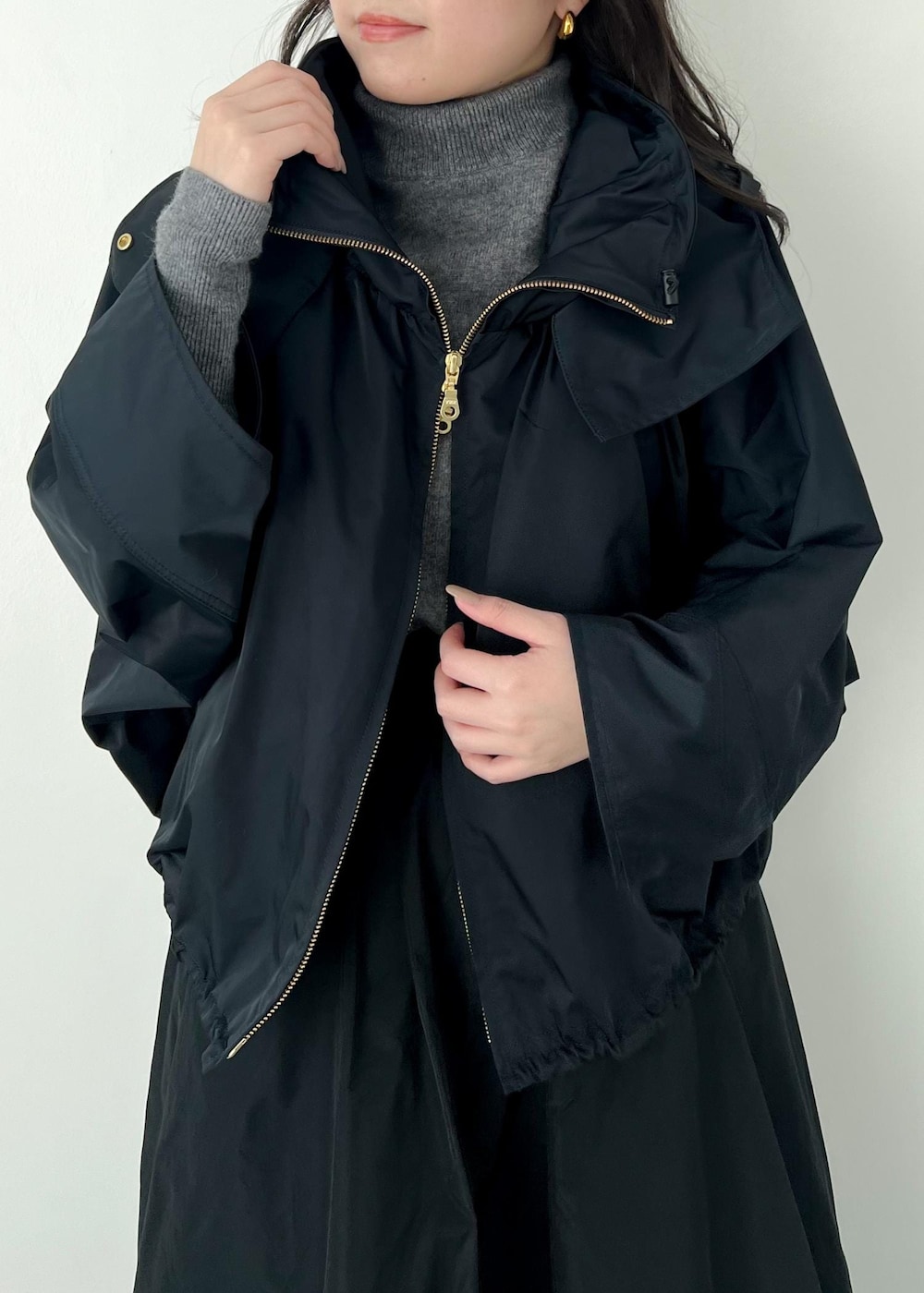 グレー系のニット/セーター、ブルー系のマウンテンパーカー、ブラック系のパンプスを着用したレディースの冬コーディネートの4枚目の写真